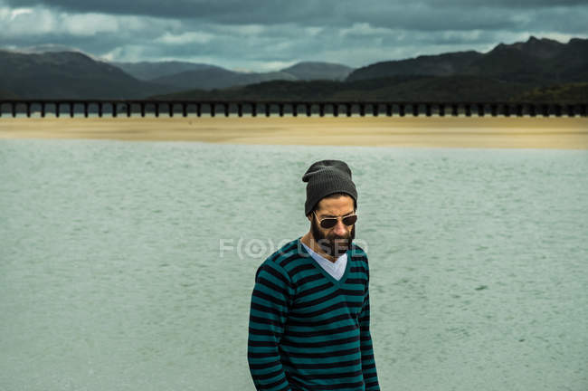 Homem em pulôver em pé na praia — Fotografia de Stock