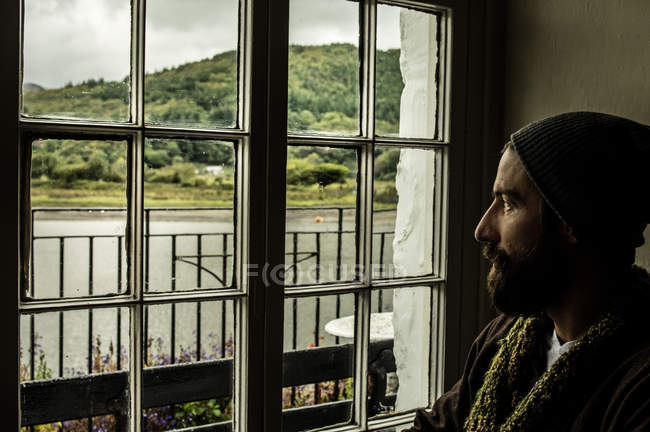 Человек смотрит в окно на живописный вид — стоковое фото