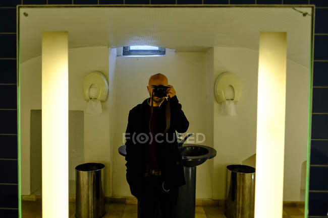 Людина Беручи фотографії з камери в дзеркало — стокове фото