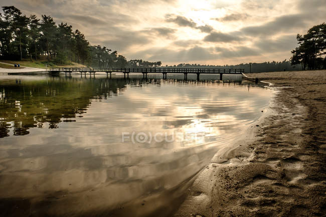 Ponte de madeira através da costa do lago — Fotografia de Stock