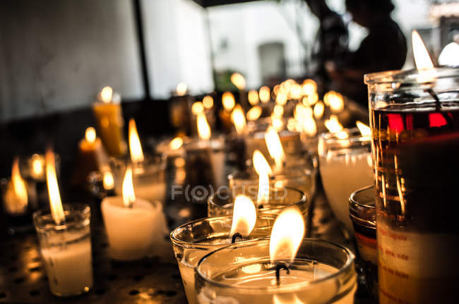 Filas de velas encendidas - foto de stock