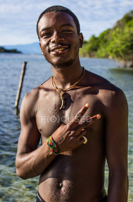 Man showing peace sign and looking at camera — Stock Photo