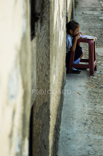 Girl doing her homework on street — Stock Photo