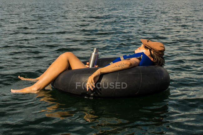 Woman relaxing on swim ring — Stock Photo