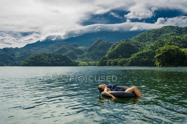 Femme relaxant sur anneau de natation — Photo de stock