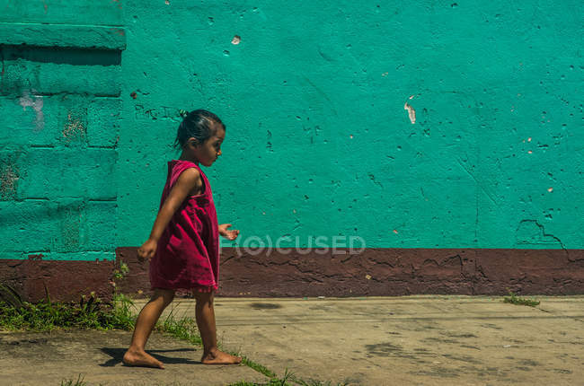 Menina andando ao longo da casa — Fotografia de Stock