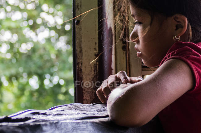 Girl sitting near window — Stock Photo