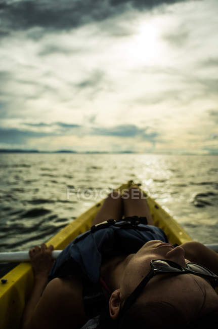 Mujer acostada en kayak - foto de stock