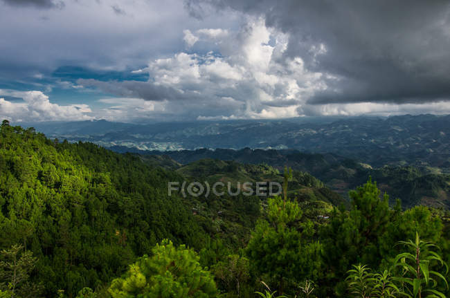 O sol que estoura através das nuvens nas colinas da selva — Fotografia de Stock