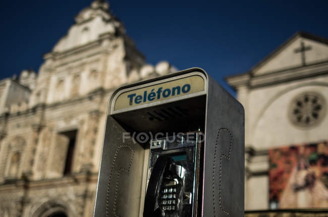 Téléphone de rue avec église en arrière-plan — Photo de stock