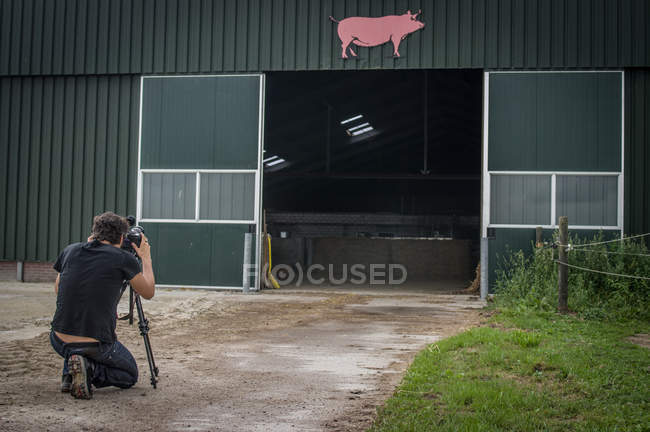 Homme prenant une photo de la ferme — Photo de stock