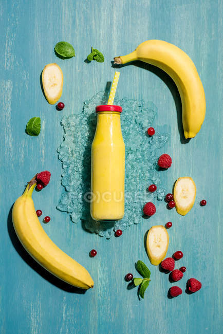 Bottle with smoothie and berries — Stock Photo