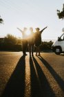 Friends standing on road and showing peace signs — Stock Photo