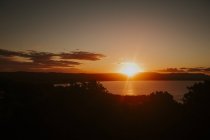 Гори і водна поверхня під час заходу сонця — стокове фото