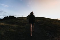 Woman walking up on mountain hill — Stock Photo
