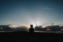 Жінка насолоджується прекрасним заходом сонця — стокове фото