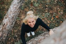Frau klettert auf Baum — Stockfoto