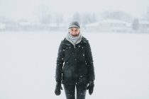 Женщина, стоящая в снежном парке в сельской местности — стоковое фото