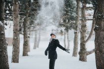 Жінка стоїть на шляху між сосновими деревами — стокове фото