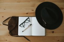 Открытая тетрадь с очками и ручкой — стоковое фото