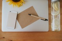 Поверхность ноутбука с открыткой и ручкой — стоковое фото