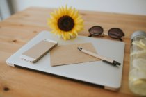 Laptop surface with postcard and pen — Stock Photo