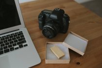 Computer portatile e fotocamera su tavolo — Foto stock