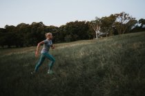 Спортивна жінка біжить на пагорбі в парку — стокове фото