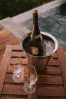 Ice bucket with champagne and two glasses — Stock Photo