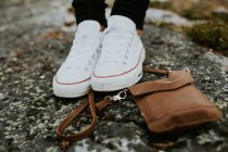 Damensportschuhe und Handtasche auf Stein — Stockfoto