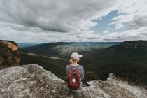 Backpackerin blickt auf Berghügel — Stockfoto