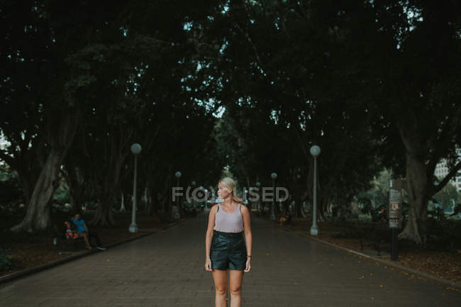 Жінка стоїть на стежці в міському парку — стокове фото