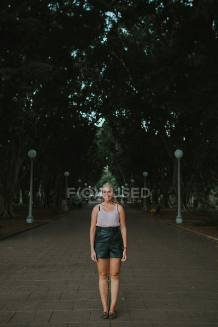 Жінка стоїть на стежці в міському парку — стокове фото
