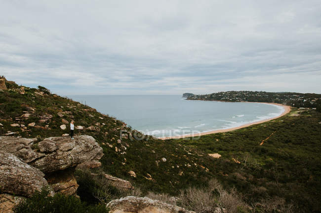Mujer de pie en la roca y mirando hermoso paisaje - foto de stock