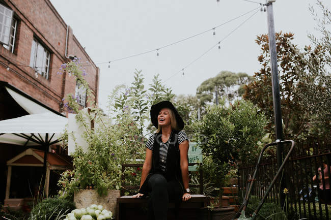 Frau sitzt auf Bank im Garten — Stockfoto