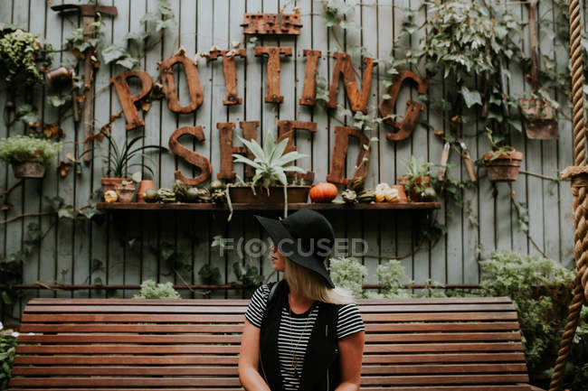 Жінка сидить на лавці в саду — стокове фото