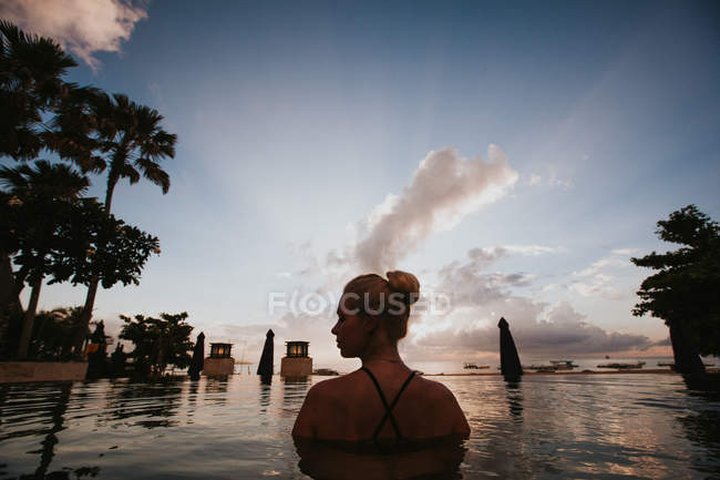 Woman sitting in water and looking at seascape — Stock Photo