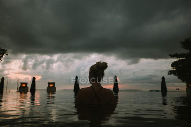 Donna seduta in acqua e guardando il paesaggio marino — Foto stock