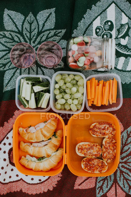 Food in plastic boxes on cloth for picnic — Stock Photo