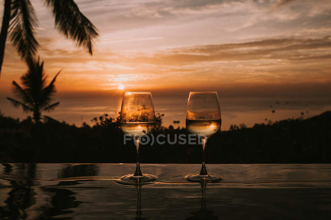 Deux verres avec des boissons sur la surface humide — Photo de stock