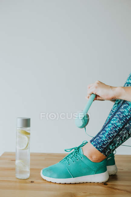 Woman holding headphones while sitting on table — Stock Photo