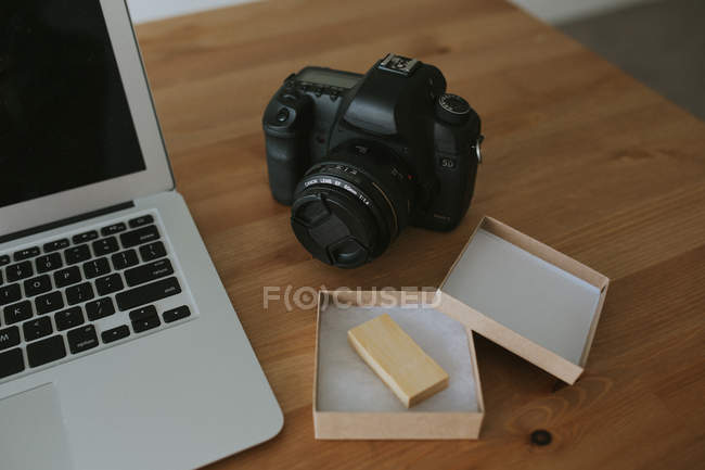 Portátil y la cámara en la mesa - foto de stock