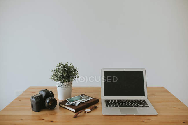 Laptop and camera on tabletop — Stock Photo