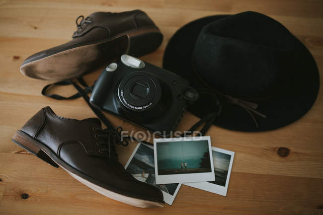 Камера, миттєві фотографії і шапочка на столі — стокове фото