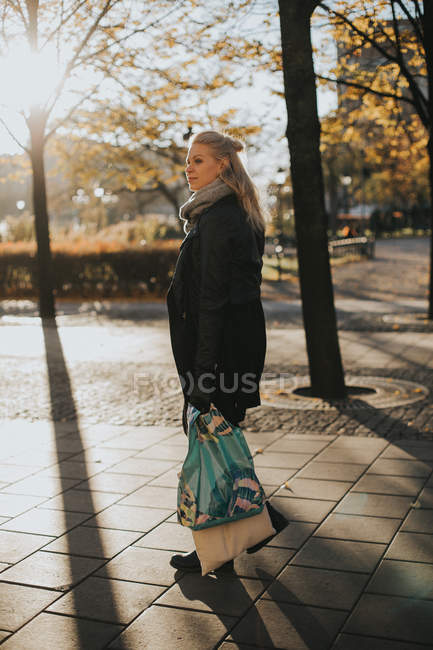 Femme debout dans la rue avec des sacs à provisions — Photo de stock