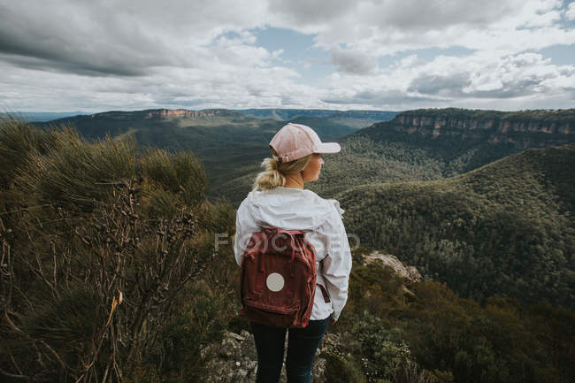 Femme routard regardant sur les collines de montagne — Photo de stock