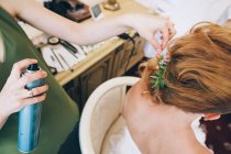 Femme mettant les cheveux à jeune mariée — Photo de stock