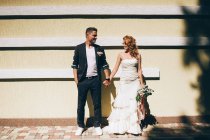 Заміжня пара позує з букетом квітів — стокове фото