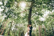 Одружений пара обіймати один одного біля дерева — стокове фото