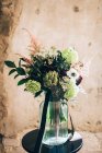 Bunch of flowers in vase placed on table — Stock Photo